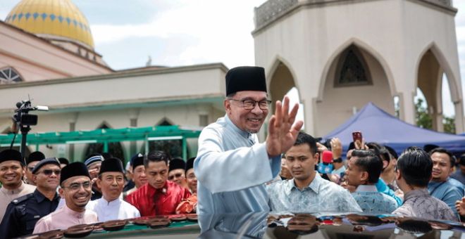 Anwar melambai tangan selepas menunaikan solat Jumaat bersama rakyat di Masjid Bandar Utama Batang Kali hari ini. - Gambar BERNAMA