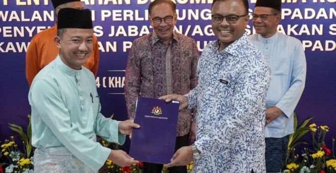 SERAH: Anwar menyaksikan KSU KDN, Datuk Ruji Ubi menyerahkan dokumen terma rujukan MCBA kepada Presiden PPTD, Datuk Seri Isham Ishak (dua kanan).
