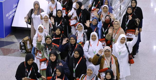 Para jemaah haji wanita kumpulan pertama melambaikan tangan sebelum berlepas ke tanah suci pada 12.05 malam ini dari Lapangan Terbang Antarabangsa Kuala Lumpur (KLIA) Terminal 1 malam tadi.-Gambar BERNAMA