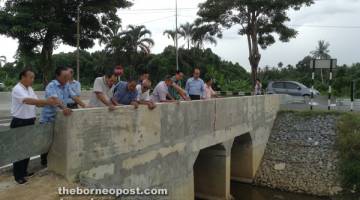 TINJAU: Lee (tiga kanan) ditemani wakil JKR, kontraktor dan penduduk meninjau keadaan jambatan baharu Kampung Katong di Miri semalam. 