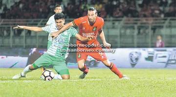 HALANG: Pemain Melaka (depan) menghalang pergerakan penyerang Sarawak, Mateo Roskam pada perlawanan Liga Super 2017 di Stadium Negeri Kuching malam tadi. — Gambar Chimon Upon