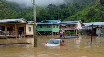 TIDAK SEMPAT ALIH: Salah sebuah kereta ditenggelami air banjir ekoran paras air naik mendadak.