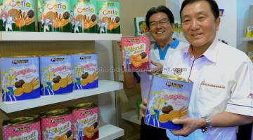 BUATAN TEMPATAN: Ong (kanan) bersama Pengarah Urusan Perfect Food Manufacturing Sdn Bhd, Su Chin Hock menunjukkan produk keluaran kilang Perfect Food ketika melawat kilang tersebut di Alor Gajah kelmarin. — Gambar Bernama