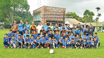 BERI SOKONGAN: Sebastian (barisan belakang, lima kiri) bersama pemain-pemain Akademi Bola Sepak Wisma di Padang Pusat Belia Miri semalam.