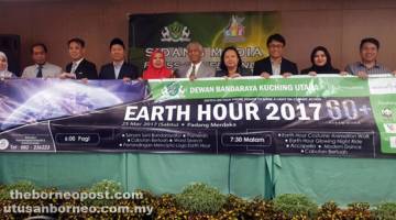 KERJASAMA: Abang Abdul Wahap (lima kanan) dan Saadiah (lima kiri) bersama Peing (empat kanan), Hon (tiga kanan), Cheah (empat kiri), Tang (tiga kiri) dan Aelma serta yang lain beraksi dengan kain rentang program Earth Hour 2017 yang diadakan pada 25 Mac ini di Padang Merdeka.