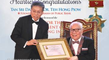 TAHNIAH: Pengarah Urusan Public Bank Tan Sri Datuk Sri Tay Ah Lek menyampaikan sijil anugerah kepada Teh bagi pihak Gabenor The State Bank of Vietnam.