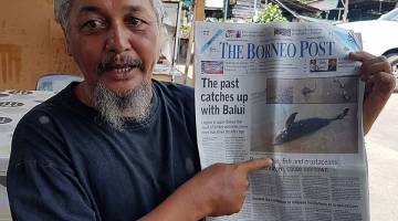 ANGKARA MANUSIA?: Kamberi menunjukkan laporan akhbar The Borneo Post pada Ahad lalu sambil memberitahu beliau dan rakan-rakan nelayan lain khuatir punca fenomena tersebut mungkin disebabkan aktiviti mengebom ikan.