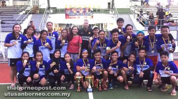 TERBAIK: Rudi (berdiri tujuh kiri) bergambar bersama pasukan perempuan dan lelaki Warrior HC yang masing-masing dinobatkan sebagai juara dan tempat ketiga pada Pesta Hoki Petra Jaya di Stadium Hoki Sarawak, baru-baru ini.