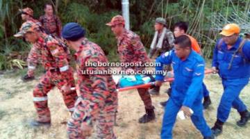 MUJUR SELAMAT: Mangsa diusung oleh anggota penyelamat keluar dari dalam hutan tersebut untuk dihantar ke hospital.