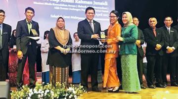 TAHNIAH: Dr Abdul Rahman (tengah) menyampaikan anugerah kecemerlangan kepada salah seorang penerima pada majlis tersebut, semalam.