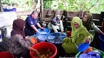 ERAT SILATURAHIM: Tiong (dua kiri) menyertai golongan wanita di Kampung Nyalau membasuh pinggan mangkuk pada Majlis Makan Tahun di kampung itu semalam.