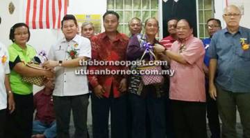 BUAH TANGAN: Dr Rayong (tiga kiri) dan Nyalau menerima cenderamata daripada wakil Rumah Erak sambil disaksikan mereka yang lain semasa Majlis Pemimpin Bersama Rakyat di Rumah Erak, Merindun Skim, Lubok Antu kelmarin.