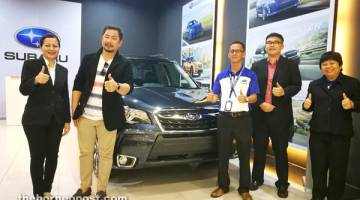 HEBAT: Ambrose (dua kiri) bersama penasihat jualan Sebangga Auto Sdn Bhd menunjukkan antara kereta Subaru yang dipamerkan di galeri pameran di Vivacity.