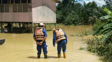 PANTAU: APM memantau kedalaman air banjir di SK Ranggong. 