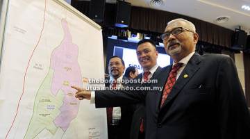 DI SINI: Mohd Hashim (kanan) menunjukkan peta DUN Pujut semasa mengumumkan tarikh PRK bagi kerusi DUN tersebut di Ibu Pejabat SPR, Putrajaya semalam.