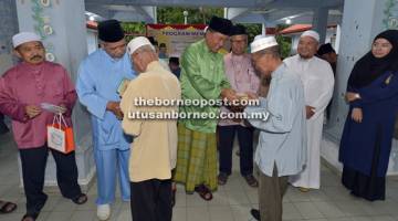 ELAK BOROS: Sapawi dan Ahmad menyampaikan sumbangan kepada wakil masjid dan surau bagi DUN Sindumin.
