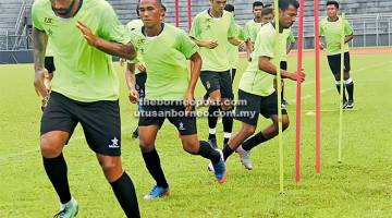 TETAP BERLATIH: Pemain menjalani latihan ringan di Stadium Negeri, Petra Jaya semalam.