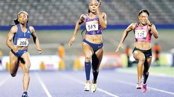 DIHADAPAN: Thompson (tengah) mendahului peserta lain dalam acara pecut 100 meter wanita pada Kejohanan Balapan dan Padang Jamaica di Stadium National Kingston di Jamaica. — Gambar Reuters