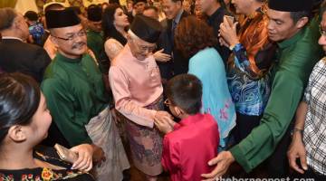 SELAMAT DATANG: Tun Taib dan Toh Puan Ragad bersalaman dengan para tetamu yang mengunjungi rumah terbuka mereka pada hari pertama Aidilfitri di Astana Negeri. 