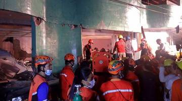 BERTINDAK PANTAS: Anggota penyelamat mencari penduduk yang terperangkap dalam bangunan yang runtuh selepas gempa bumi sekuat 6.5 pada skala Richter menggoncang bandar Kananga, wilayah Leyte di tengah Filipina kelmarin. — Gambar AFP