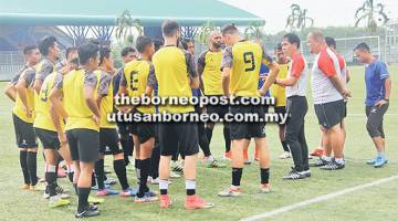 PANAS BADAN: Pengiran Bala (empat kanan) memberi arahan kepada pemain-pemain sebelum memulakan sesi latihan di Kuching kelmarin.