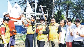 PELEPASAN: Lee dan Arrifin (kiri) menarik bendera simbolik pelepasan peserta Regata Terbuka Sarawak MCC – KFC Ke- 2 disaksikan Sherrina (kanan) dan Troy (dua kanan).