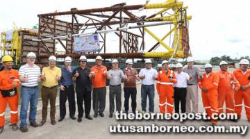 SEDIA BELAYAR: (Dari empat kiri) Jorge, Kho, Omar (tujuh kanan) dan serta yang lain bergambar berlatarbelakangkan pelantar dan ‘jacket’ Bunga Pakma-Kinabalu Wellhead Platform yang bersedia belayar pada hujung bulan ini.