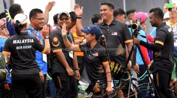 CEMERLANG: Fatin (tengah) bersama Mohd Juwaidi Mazuki meraikan kejayaan mara ke final pada acara Compound Berpasukan Campuran Sukan SEA KL2017 di Padang Sintetik Bukit Jalil pada 18 Ogos lepas. — Gambar Berrnama