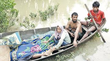 TERDESAK: Gambar fail 6 September lalu menunjukkan penduduk Rohingya membawa mayat rakan mereka dengan bot setelah ditemui susulan insiden bot karam di Sungai Naf, dekat Ulubunia di Ukhiya. — Gambar AFP