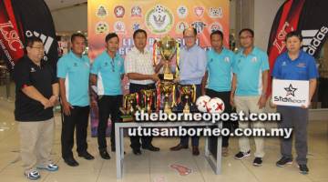 TAJAAN: John menerima Trofi Kejohanan Bola Sepak Liga Serian-LSC 2017 daripada Raymond pada majlis penyerahan tajaan di Sarawak Plaza, Kuching semalam. Turut hadir, Philip Jabu.