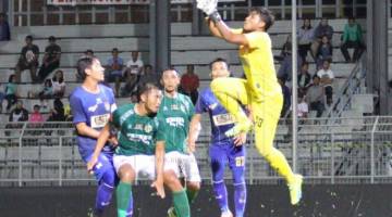 Penjaga gol UKM FC, Abdul Gapur Samsudin tangkas menyelamatkan gawang pasukannya dari ancaman penyerang Kuching FA (jersi hijau).