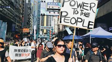 BANGKIT LANTANG: Aktivis prodemokrasi mengadakan perarakan protes sempena sambutan hari kebangsaan China di Hong Kong, semalam. — Gambar Reuters