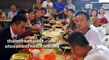 TANDA INGATAN: Lee (berdiri, dua kanan) menyampaikan cenderamata kepada ketua pasukan Wu Dehua semasa jamuan tengah hari di Kuching, semalam.