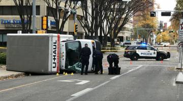 MENCEMASKAN: Anggota polis menjalankan siasatan di tempat kejadian di mana trak dipandu suspek terbalik ketika dikejar polis di persimpangan 107 Street dan 100th Avenue di hadapan Hotel Matrix di Edmonton, Alberta kelmarin. — Gambar Reuters
