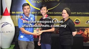 TAHNIAH: Dunstan menyampaikan hadiah kepada salah seorang pemenang pada Pertandingan Boling Unity di Kuching.