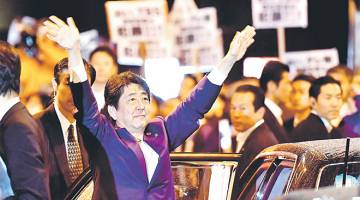 DISOKONG: Abe melambai kepada penyokong ketika meninggalkan lokasi kempen terakhir untuk pilihan raya umum ke-22 di Tokyo kelmarin. — Gambar AFP