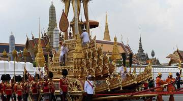 PENUH PENGHORMATAN: Anggota tentera diraja Thai menarik Rajarot Noi ketika upacara pengebumian bermula untuk Raja Bhumibol di Bangkok, semalam. — Gambar AFP