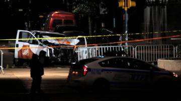 KEKEJAMAN MELAMPAU: Trak pikap yang digunakan dalam serangan itu diteliti polis di Manhattan, New York semalam. — Gambar Reuters