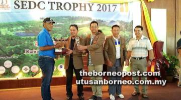 TAHNIAH: Juara keseluruhan kejohanan golf Piala SEDC 2017, Mobil (kiri) menerima Trofi Cabaran SEDC daripada Abdul Aziz sambil disaksikan Pengurus Besar SEDC, Soedirman Aini, Pengurus Besar DGCC, Roslan Mohd Salleh.