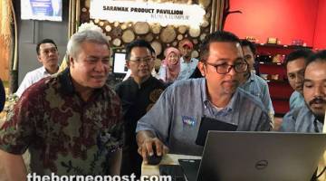 PRODUK SARAWAK: Awang Tengah melihat transaksi jualan produk usahawan Sarawak semasa prapelancaran Sarawak Product Pavillion di Jalan Tuanku Abdul Rahman, Kuala Lumpur.