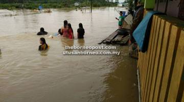 TENGGELAM: Jalan raya tenggelam akibat banjir setinggi kira-kira dua kaki setengah di Niah, Subis.