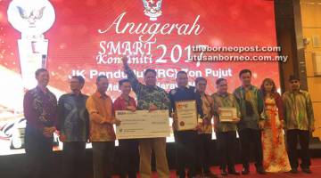TAHNIAH: Menerima sijil dan anugerah Platinum Anugerah Smart Community daripada Menteri Muda Kerajaan Tempatan Datu Dr Penguang Manggil (tiga kiri). 