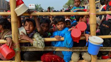 PENUH DERITA: Kanak-kanak pelarian warga Rohingya mendapatkan bekalan makanan yang dihantar ke kem pelarian Thankhali di daerah Ukhia, Bangladesh. — Gambar AFP