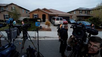 DITANGKAP: Kru media berhimpun di luar rumah David Allen (kanan) dan Louise Anna di Perris, California kelmarin selepas mereka ditangkap kerana didakwa mengurung 13 anak mereka di dalam rumah tersebut. — Gambar Reuters/AFP