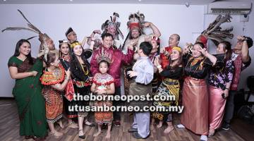 TERUJA: Devon (barisan belakang, kanan) dan Murray (dua kiri) memberi ‘pose’ istimewa sambil menggayakan pakaian tradisional Iban semasa sesi fotografi bersama Matthew (barisan belakang, kiri), Stephen (barisan tengah, tiga kanan), Teng (barisan tengah, lima kanan) dan yang lain.