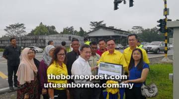 MEMUDAHKAN: Lo dan Dr Sim bersama yang lain semasa pelancaran lampu isyarat pintar                                                   di persimpangan Kampung Haji Baki, Kuching, semalam.