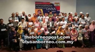 UNTUK ALBUM: Dr Abdul Rahman (duduk, tengah) bersama tetamu kehormat lain merakam kenangan bersama wakil-wakil penerima dana DUN Pantai Damai.