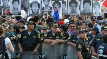 KECOH: Anggota polis berkawal di hadapan ratusan penunjuk perasaan yang berhimpun di Lima kelmarin buat kali kelima                           bagi membantah keputusan presiden memberi pengampunan kepada bekas presiden Alberto Fujimori.  — Gambar AFP