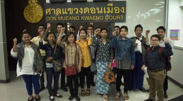 PERTAHAN HAK: Pekerja pendatang dari Myanmar menunjukkan isyarat ingkar di hadapan media sebelum memasuki Mahkamah Majistret Don Muang di Bangkok semalam untuk berdepan tuduhan memfitnah ladang ayam Thammakaset kerana mendakwa berlaku penderaan buruh. — Gambar AFP