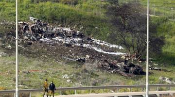 BERKECAI: Gambar yang diambil di Kibbutz Harduf, utara Israel, semalam menunjukkan bangkai sebuah pesawat Israel F-16 yang terhempas setelah ia diserang oleh pertahanan udara Syria sewaktu serangan ke atas ‘sasaran Iran’ di negara bergolak itu. — Gambar AFP